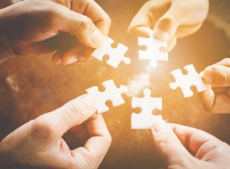 balanced media plan represented by hands connecting jigsaw puzzle pieces